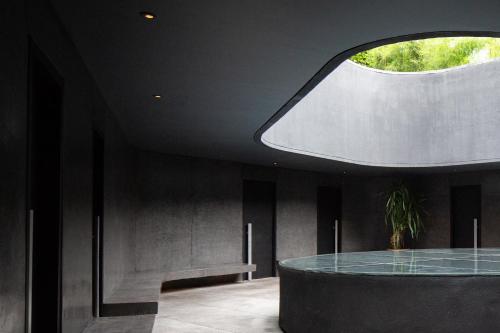 a room with a glass table and a window at Potato Head Suites & Studios in Seminyak
