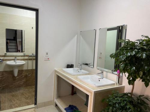 a bathroom with two sinks and a large mirror at Nhật's Sapa Central Hostel in Sa Pa