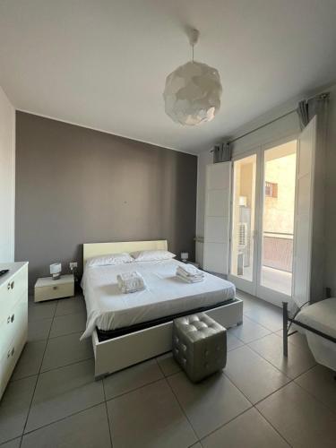 a bedroom with a white bed and a large window at Via Itria in Marsala
