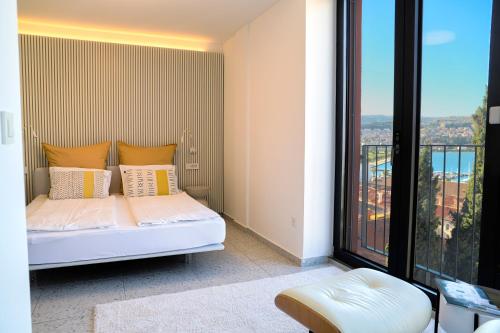 een slaapkamer met een bed en een groot raam bij Koper Seaside Residence in Koper