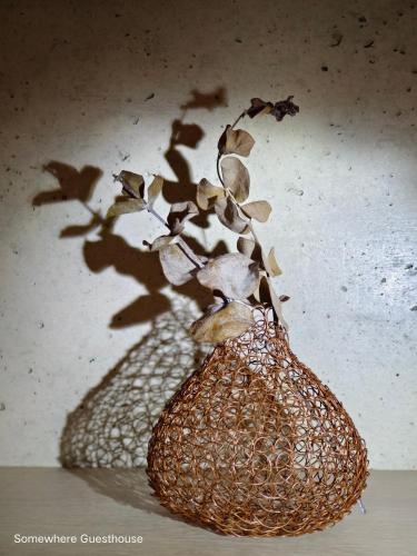 a rattan vase with a plant in it at Penghu Somewhere Guesthouse 澎湖嶼光角落民宿 in Magong