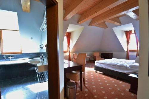 1 dormitorio con cama, escritorio y lavamanos en Hotel Hradna brana, en Bratislava