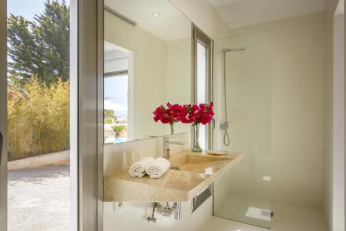 baño con lavabo y jarrón de flores en Casa Flopos - Ibiza, en Nuestra Señora de Jesús