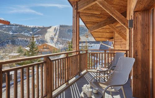 a balcony with chairs and a view of the mountains at Résidence Odalys Le Mont d'Auron in Auron