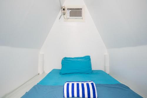 a bed with a blue comforter and a pillow at Costas De Liwa Bar & Beach Resort in Zambales