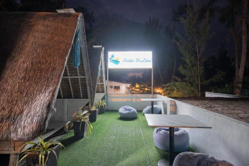 a patio with a table and a sign at night at Costas De Liwa Bar & Beach Resort in Zambales