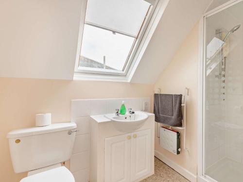 a bathroom with a toilet and a sink and a window at 4 Bed in Studland 75639 in Studland