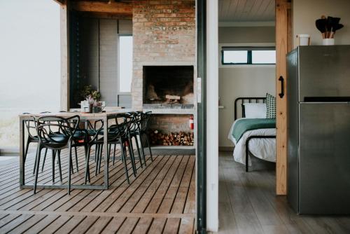 a dining room with a table and chairs and a fireplace at KORF Cabin in Saron