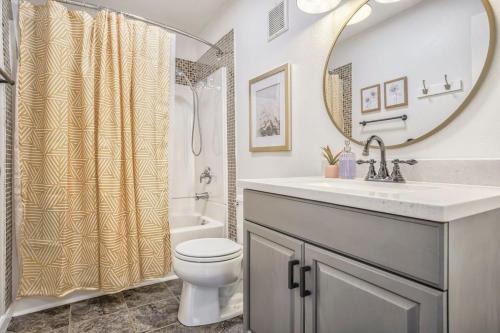 a bathroom with a sink and a toilet and a mirror at Colorado Cottage - Downtown King Scenic in Colorado Springs