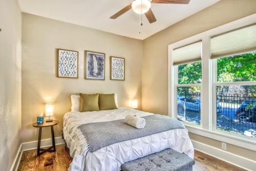 a bedroom with a bed and a ceiling fan and windows at Corona Victorian - Downtown Hot Tub Scenic View in Colorado Springs