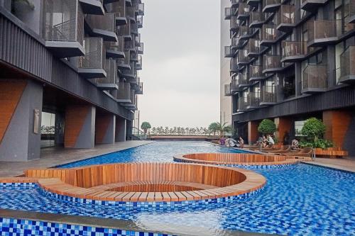 a large swimming pool with a fountain in the middle of a building at Cozy Stay Studio Apartment for 4 Persons at Carstensz Residence By Travelio in Kramat