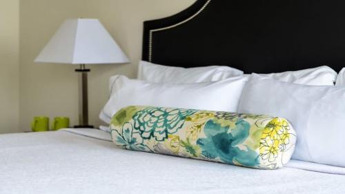 a pillow sitting on top of a bed at 23rd FL Bold CozySuites with pool, gym, roof in Dallas