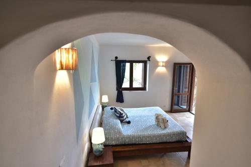 a bedroom with a bed with a blue blanket at Villa Minda Lodge & View in San Teodoro