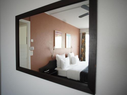 a mirror reflecting a bed in a hotel room at Primadom Aparthotel in Geneva