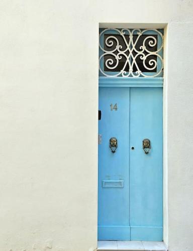 een blauwe deur in een gebouw met een raam bij Charming Senglea Studio in Senglea
