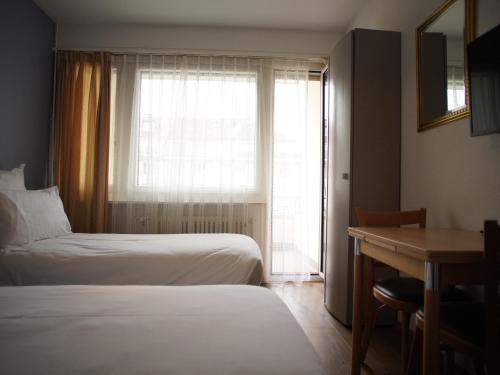 a hotel room with two beds and a window at Primadom Aparthotel in Geneva