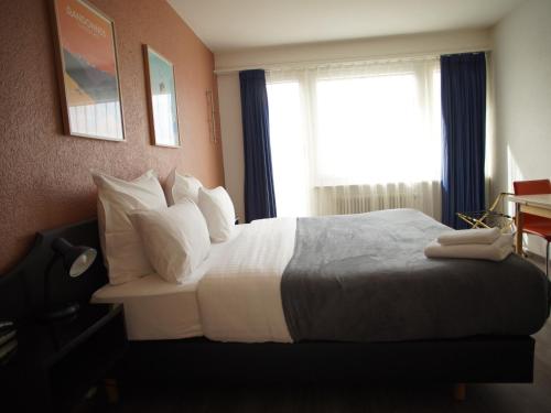 a hotel room with a bed and a window at Primadom Aparthotel in Geneva