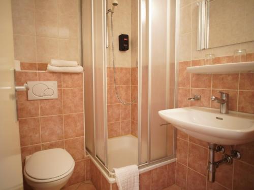 a bathroom with a shower and a toilet and a sink at Primadom Aparthotel in Geneva