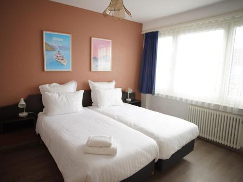 a bedroom with two beds with white pillows at Primadom Aparthotel in Geneva
