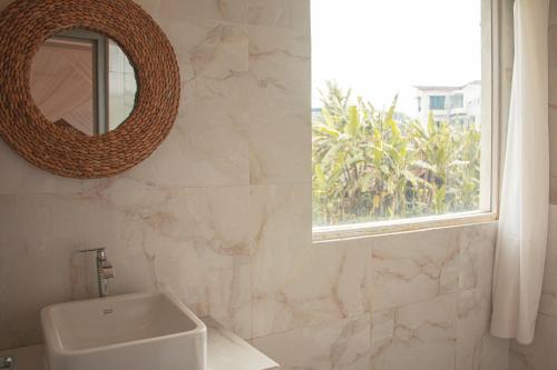 ein Badezimmer mit Waschbecken, Spiegel und Fenster in der Unterkunft Villa Holy By The Villas 100 in Bogor