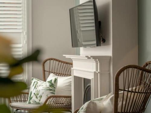 a living room with two chairs and a tv on a fireplace at Pass the Keys Luxury 2 Bedroom Townhouse in Central St Albans in St. Albans
