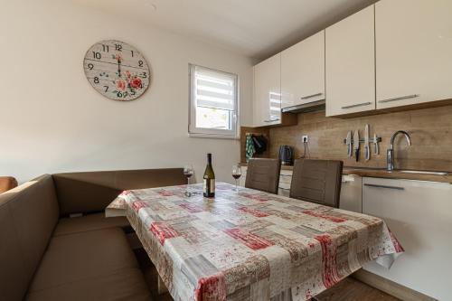 eine Küche mit einem Tisch und einer Uhr an der Wand in der Unterkunft Cozy Apartment Bovec - Happy Rentals in Bovec