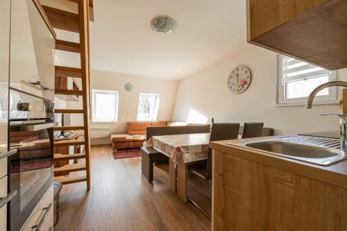 eine Küche mit einem Waschbecken und ein Wohnzimmer in der Unterkunft Cozy Apartment Bovec - Happy Rentals in Bovec