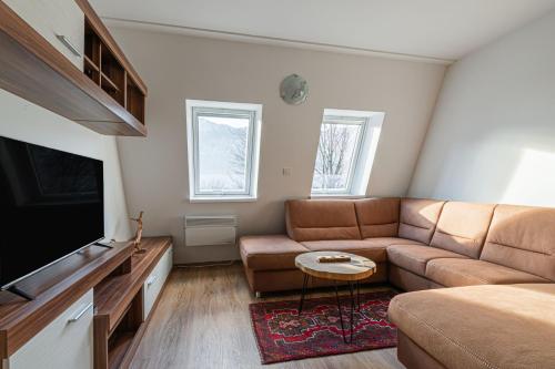 Una sala de estar con un sofá y un televisor de pantalla plana. en Cozy Apartment Bovec - Happy Rentals, en Bovec