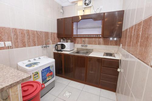 a small kitchen with a sink and a stove at Taraf Al Asalah Villas in An Nimāş
