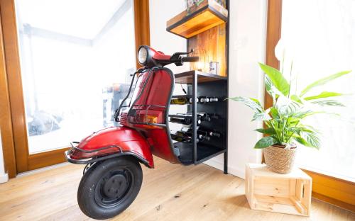 a red scooter parked in a room with a plant at FEWO PARTNERS - Fewo Bella Donna 95qm in Wildau Nähe BER-Airport in Wildau
