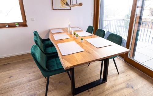 a conference room with a wooden table and green chairs at FEWO PARTNERS - Fewo Bella Donna 95qm in Wildau Nähe BER-Airport in Wildau
