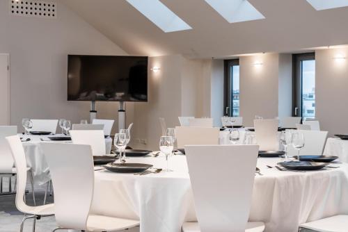 a conference room with white tables and white chairs at Akeah Verdi Budapest in Budapest