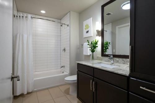 uma casa de banho com um lavatório, um WC e uma banheira em CozySuites TWO Bright And Comfy Apartments em Dallas