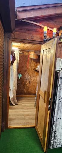 otwarte drzwi do pokoju z zieloną podłogą w obiekcie Letnia willa z sauną w mieście Darłowo