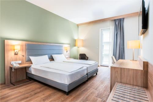 una camera d'albergo con letto e TV di Akeah Verdi Budapest a Budapest