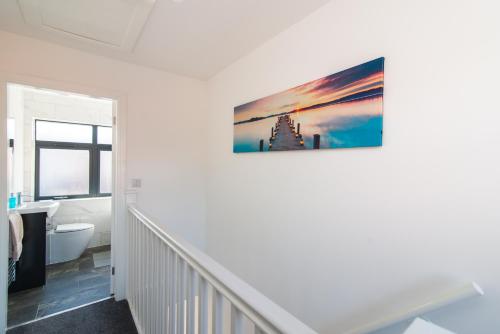 a white bathroom with a picture on the wall at Spacious Luxury 2 Bedroom House in Derby