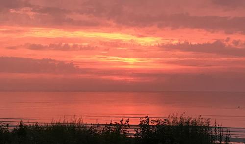 a sunset over the ocean with the sky at Strandhotel Dünenhaus in Juliusruh