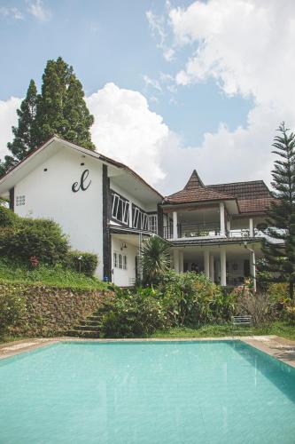 a house with a swimming pool in front of it at Villa Eldorado By The Villas 100 in Cisarua