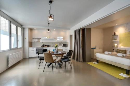 un salon avec un lit, une table et des chaises dans l'établissement Modern and eclectic 3BD duplex in Le Marais!, à Paris