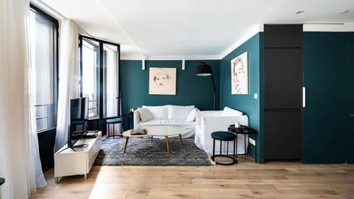 - un salon avec un canapé blanc et des murs verts dans l'établissement Bright & renovated 3BD for 8 guests in Le Marais!, à Paris