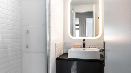 une salle de bain avec un lavabo et un miroir dans l'établissement Bright & renovated 3BD for 8 guests in Le Marais!, à Paris