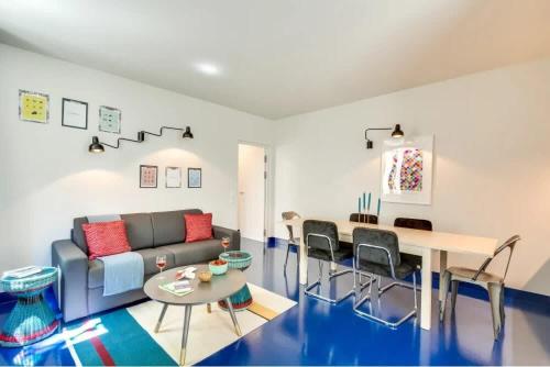 un salon avec un canapé et une table dans l'établissement Modern & colourful 3BD for 9 guests in Le Marais!, à Paris