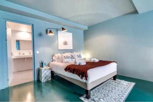 une chambre avec un lit dans une pièce bleue dans l'établissement Modern and bright 2BD for 11 guests in Le Marais!, à Paris