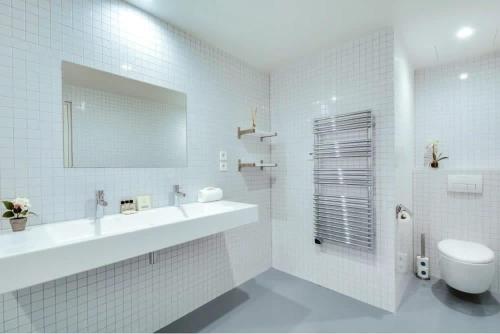 a white bathroom with a sink and a toilet at Modern and bright 2BD for 11 guests in Le Marais! in Paris
