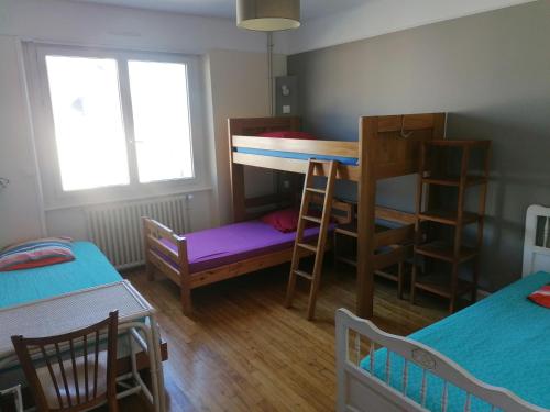 a room with two bunk beds and a table and chairs at Bigouden Backpacker in Tréffiagat