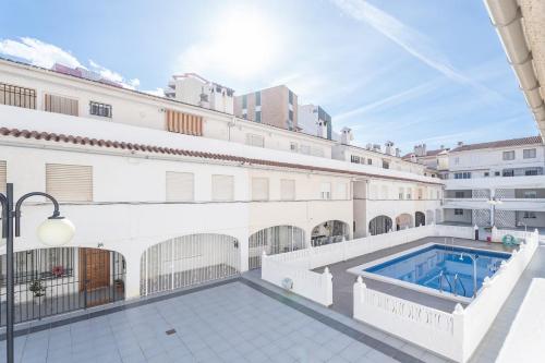 a large white building with a swimming pool at Bungalow PLAYA POBLA DE FARNALS in Las Canteras