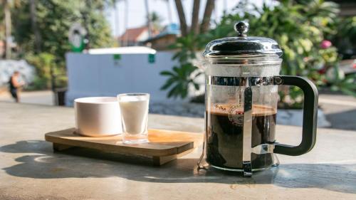 a coffee maker and a cup of coffee on a table at Mad Monkey Luang Prabang in Luang Prabang