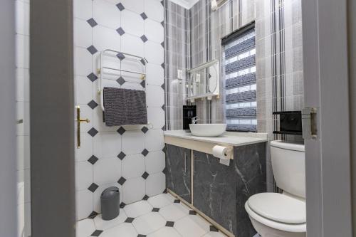 a bathroom with a toilet and a sink at Roslin Apartments in Johannesburg