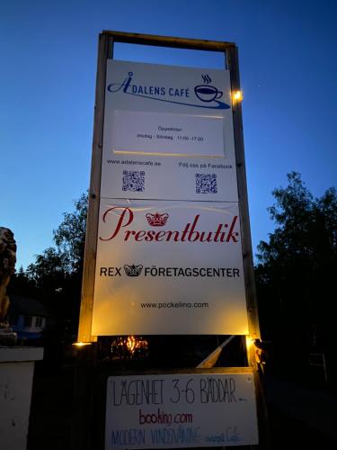 a sign for a restaurant with lights on it at Stor lägenhet ovanpå café ute på landet in Hökerum