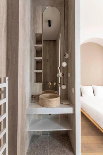 La salle de bains est pourvue d'un lavabo et d'un miroir à côté du lit. dans l'établissement Tour Eiffel - Champ de Mars Exquisite 3BD 3BTH, à Paris